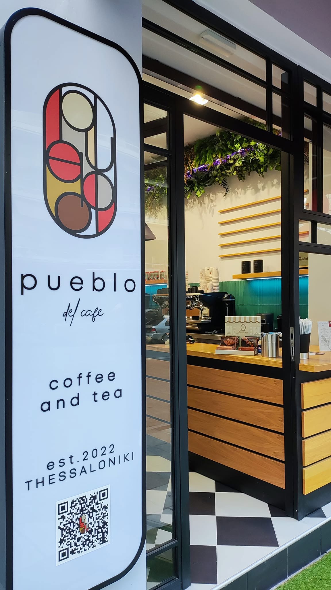 Η φωτεινή επιγραφή Pueblo del café στην είσοδο